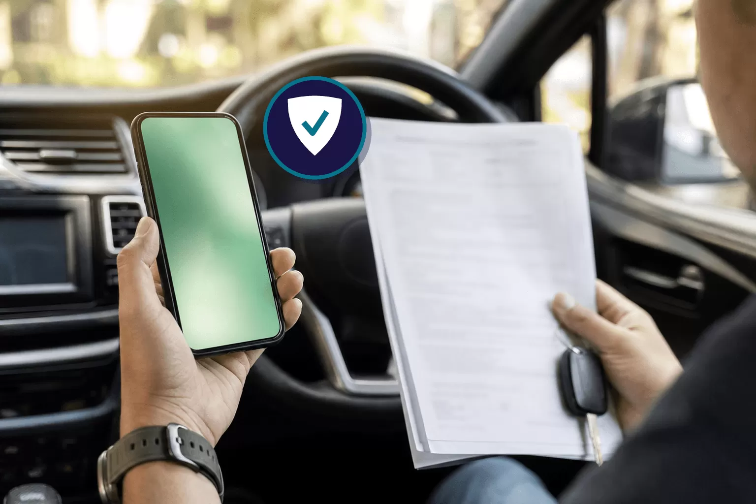 Driver checking car insurance details on a phone beside a parked car
